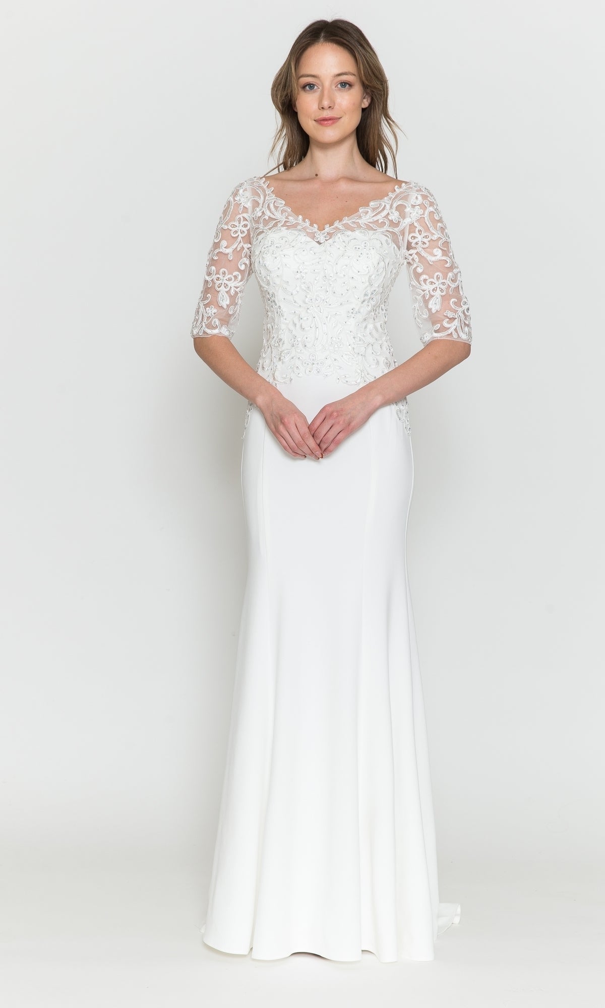 A woman faces forward wearing the Embroidered Sheer-Sleeved Formal Prom Dress 8560 in off white, featuring a floor-length design, embroidered details, lace sleeves, and a fitted bodice.